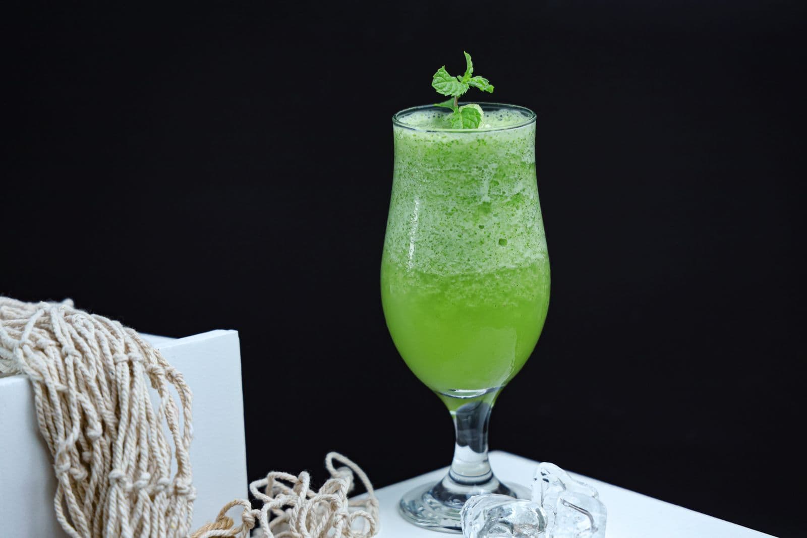 Bright green smoothie in a tall glass